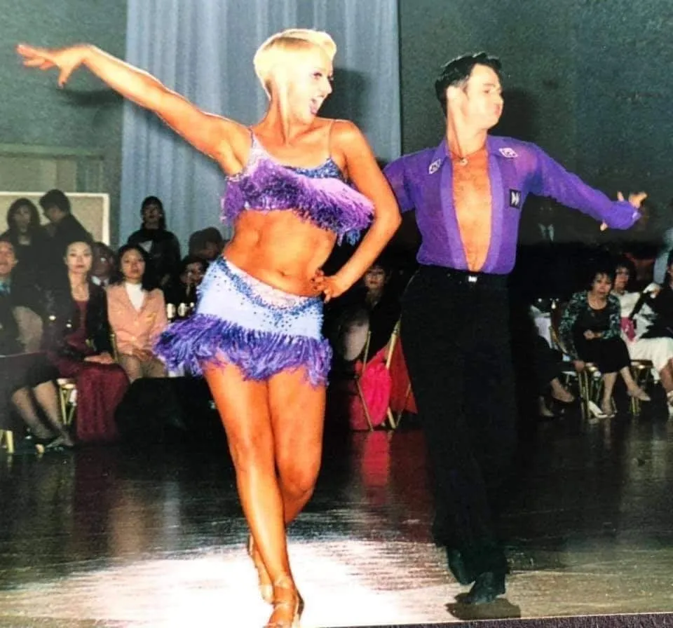 Debi performing a Latin routine in a purple costume
