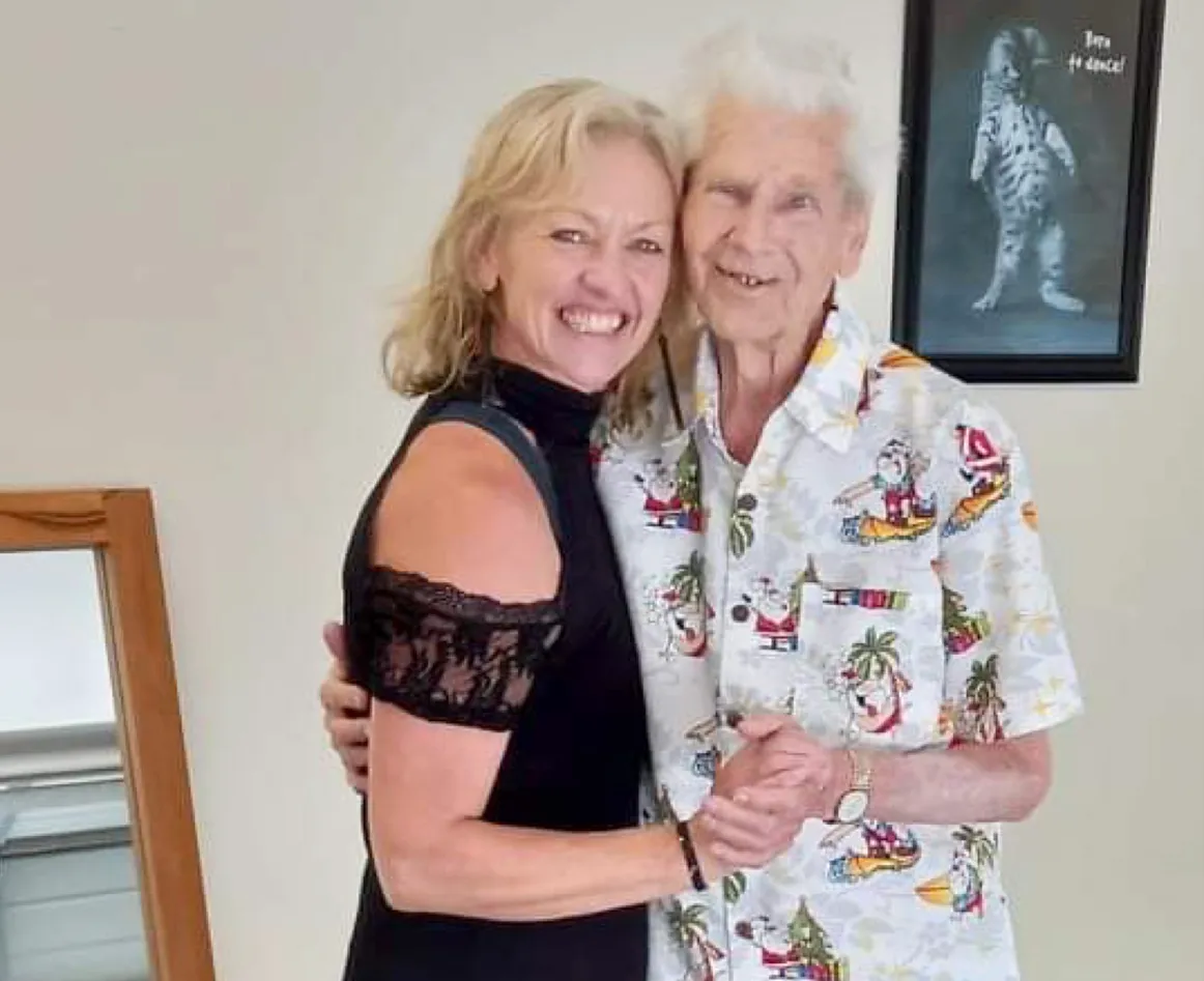 Debi smiling warmly arm-in-arm with an older student after a lesson